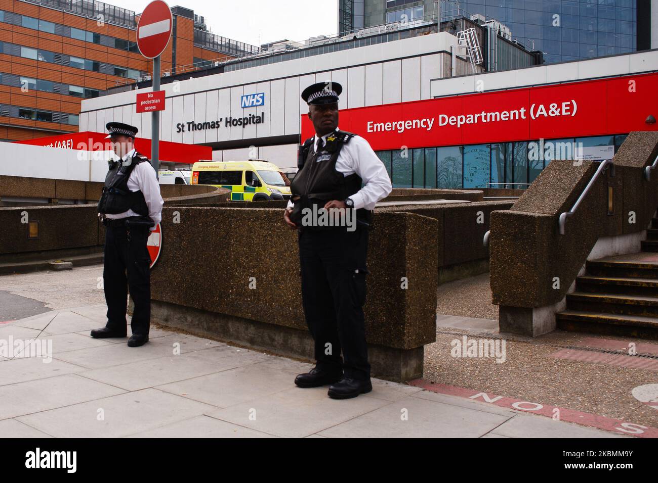 Police officers stand guard outside St Thomas' Hospital, where British Prime Minister Boris Johnson remains in intensive care with the covid-19 coronavirus, in London, England, on April 8, 2020. Johnson, 55, was admitted to the hospital on Sunday evening with what were described as 'persistent symptoms' of the novel coronavirus. He was moved to intensive care on Monday night after his condition was said to have 'worsened'. Chancellor of the Exchequer Rishi Sunak informed the country today, however, that the prime minister was now improving, sitting up and 'engaging positively' with the medical Stock Photo