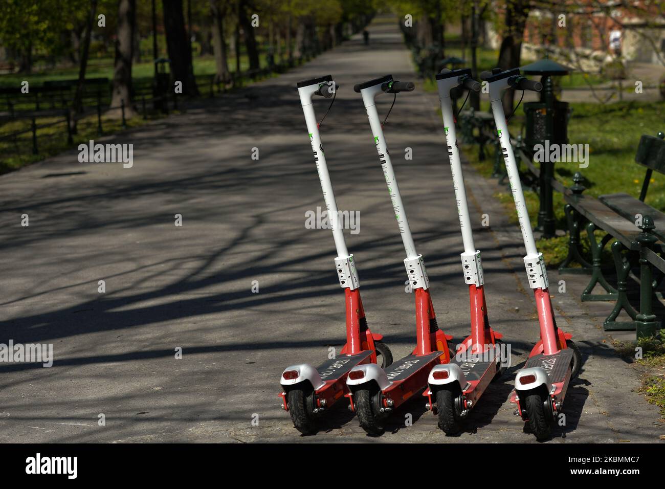 Electric scooters parked on the side in Krakow's Planty Park, as Poles can now enjoy green space again. From today (April 20), the ban on moving, traveling and staying in public places has been lifted. Public parks, forests and beaches have been reopened, with the exception of playgrounds and sports facilities. Children over 13 years can move without parents. covering mouth and nose in public still remains compulsory. Playgrounds, and sports facilities remain closed. On Monday, April 20, 2020, in Krakow, Poland. (Photo by Artur Widak/NurPhoto) Stock Photo