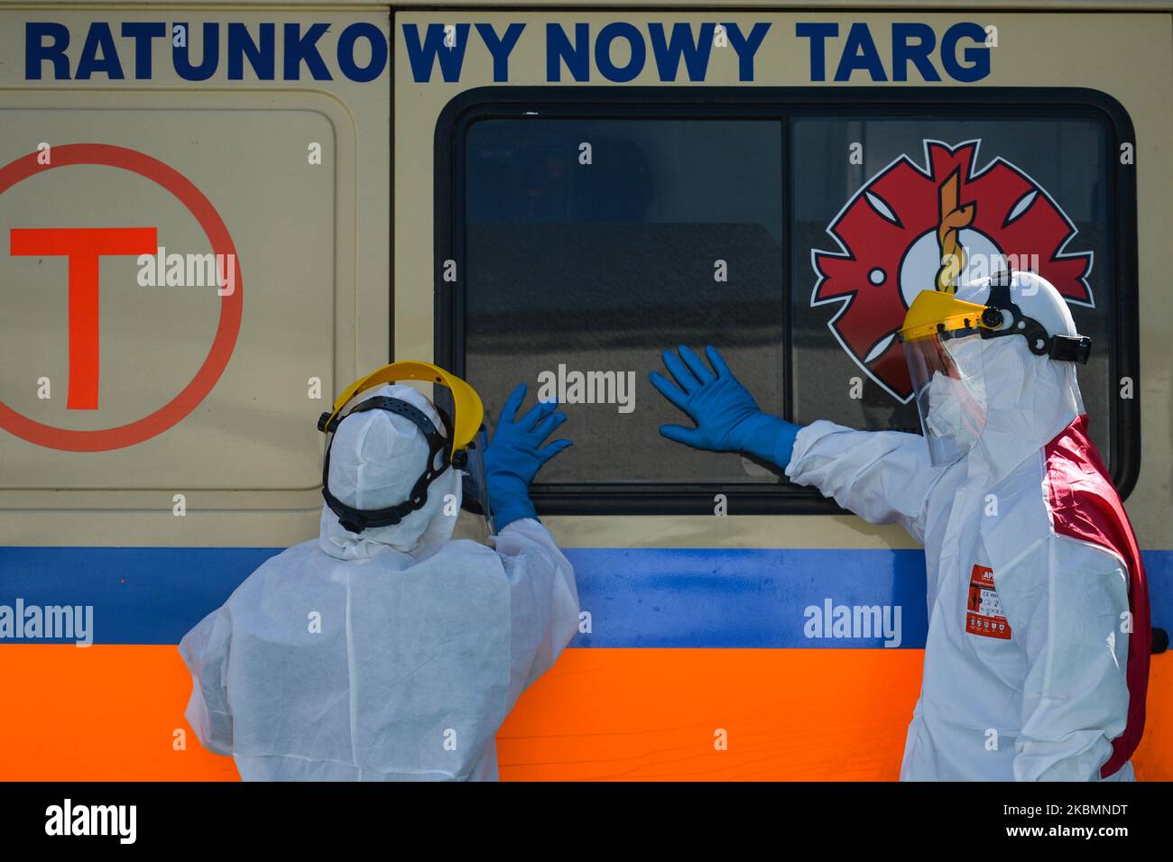 Medical workers wearing hazmat suits and protective helmets and masks, seen in the parking lot of the infectious disease ward of University Hospital in Krakow, after arriving with a patient suspected of being infected with coronavirus. On Tuesday, April 21, 2020, in Krakow, Poland. (Photo by Artur Widak/NurPhoto) Stock Photo
