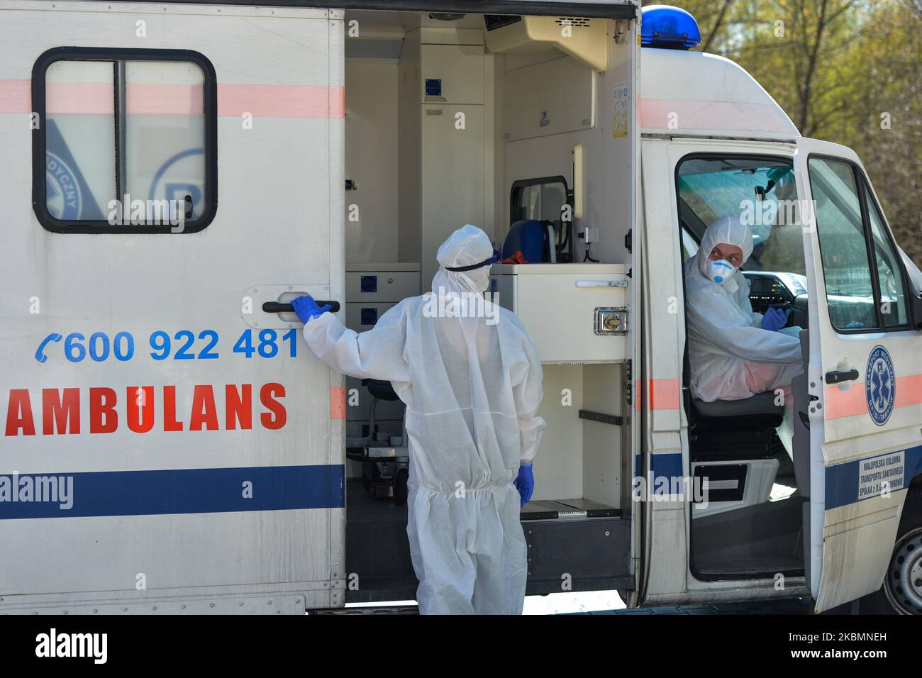 Medical workers wearing hazmat suits and protective helmets and masks, wait at the parking lot of the infectious disease ward of University Hospital in Krakow, after arriving with a patient suspected of being infected with coronavirus. On Tuesday, April 21, 2020, in Krakow, Poland. (Photo by Artur Widak/NurPhoto) Stock Photo