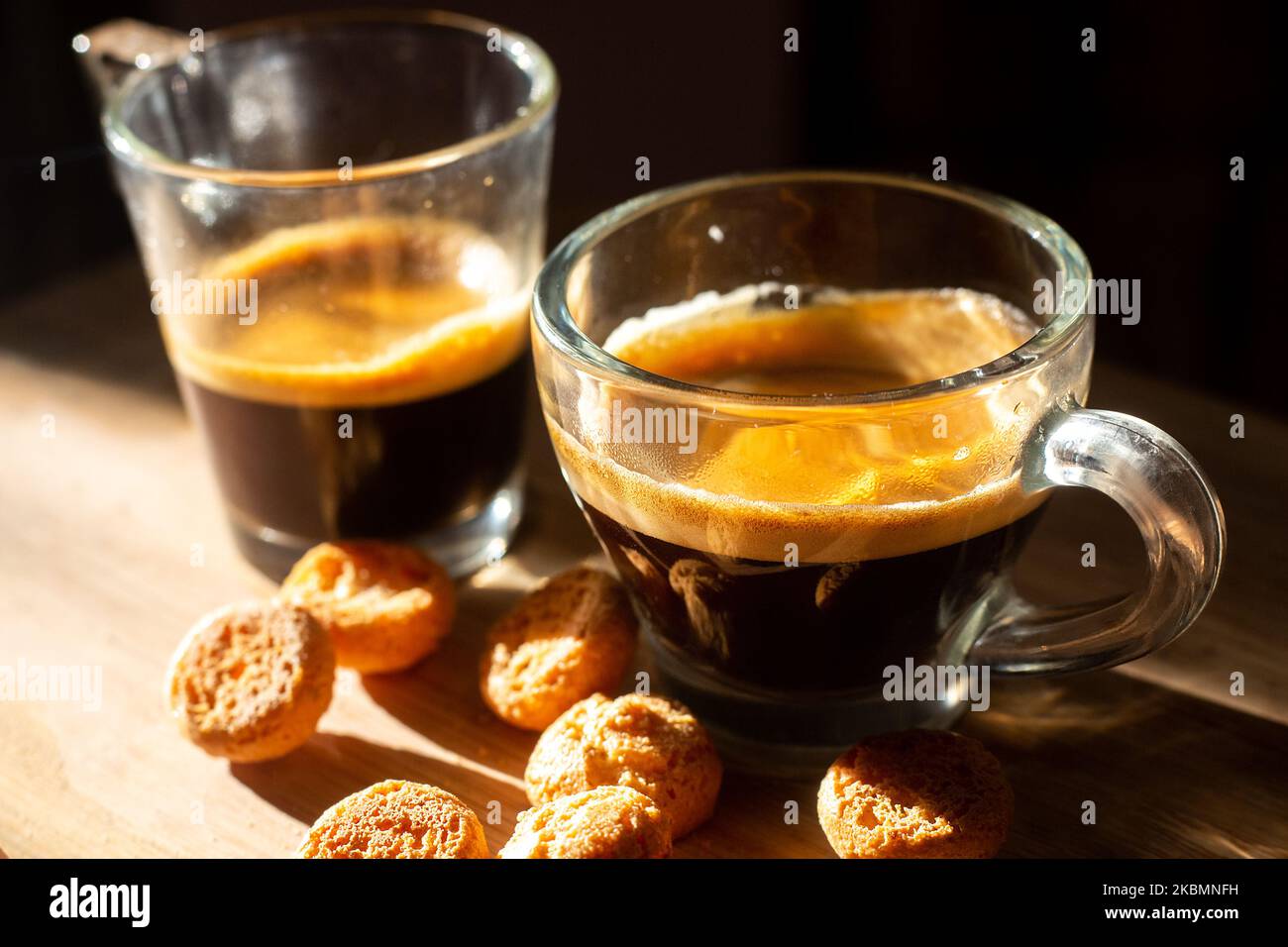 Cups of italian coffee espresso on wooden surface with small biscuits. High contrast photo in