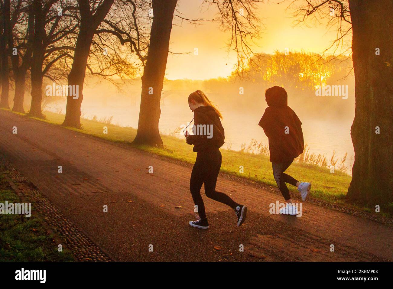 Preston, Lancashire. UK Weather 4 November, 2022.  Cold frosty, misty morning as the sun rises over the River Ribble and local residents take light exercise along the riverside walk in Avenham Park. Sunny spells are forecast after the first frost of Autumn.  Credit; MediaWorldImages/AlamyLiveNews Stock Photo