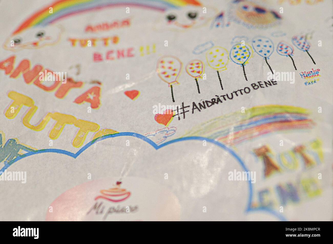 Detail on the paper for ice cream packaging containing drawings made by children with words of hope Andrà tutto bene / everything will be fine during COVID-19 pandemic in Italy on April 22, 2020 in Rolo, Italy. (Photo by Emmanuele Ciancaglini/NurPhoto) Stock Photo