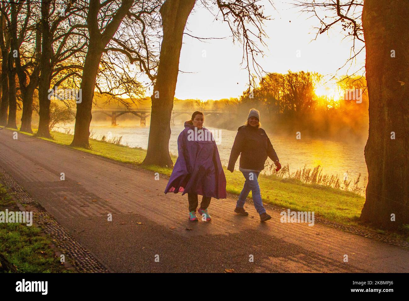 Preston, Lancashire. UK Weather 4 November, 2022.  Cold frosty, misty morning as the sun rises over the River Ribble and local residents take light exercise along the riverside walk in Avenham Park. Sunny spells are forecast after the first frost of Autumn.  Credit; MediaWorldImages/AlamyLiveNews Stock Photo