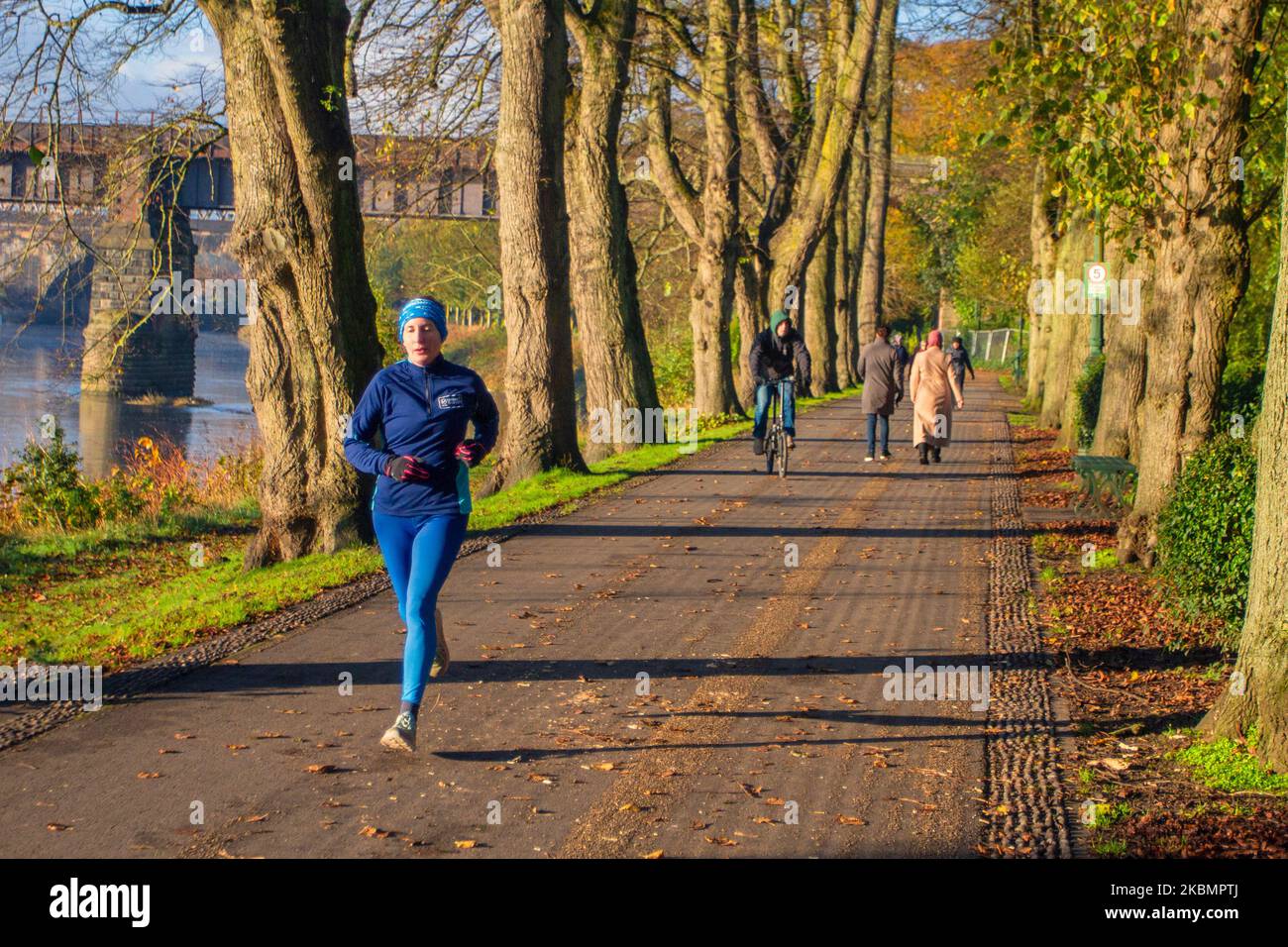 Preston, Lancashire. UK Weather 4 November, 2022.  Cold frosty, misty morning as the sun rises over the River Ribble and local residents take light exercise along the riverside walk in Avenham Park. Sunny spells after the first frost of Autumn.  Credit; MediaWorldImages/AlamyLiveNews Stock Photo