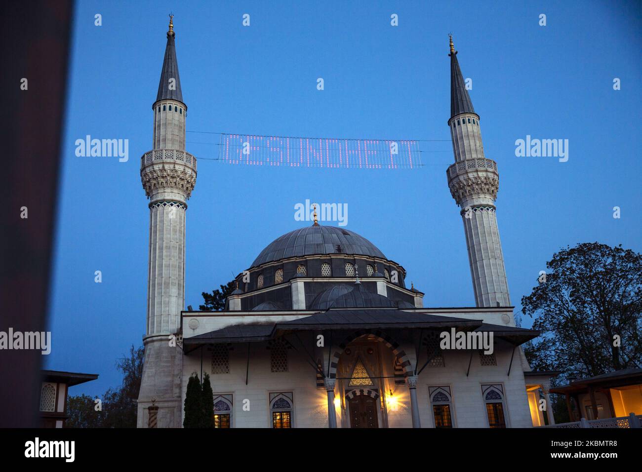 The text 'healthy' appears bewtween the minarets of the closed Sehitlik mosque in the day marking the beginning day of Ramadam in Berlin, Germany on April 23, 2020. (Photo by Emmanuele Contini/NurPhoto) Stock Photo