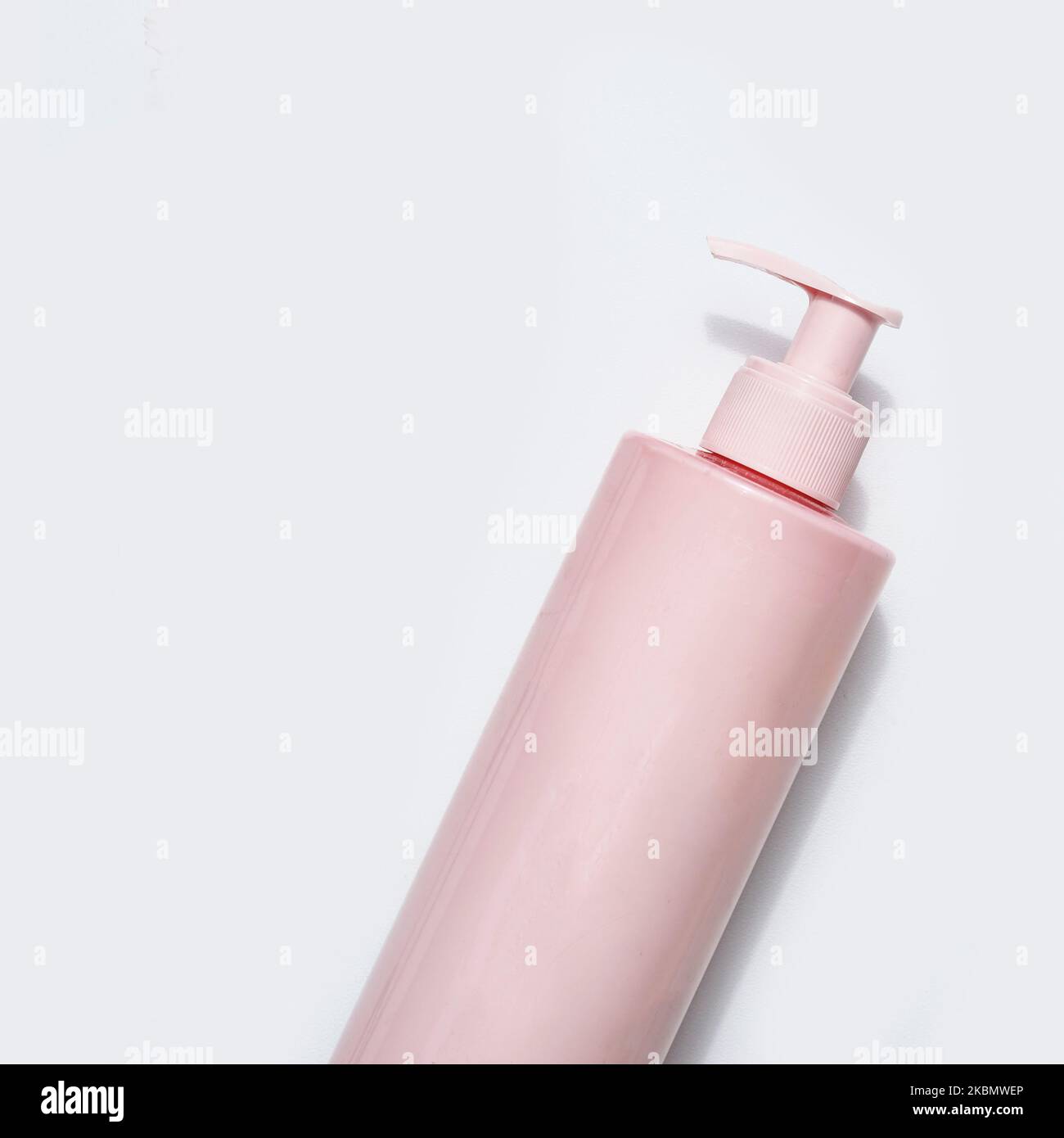 Pink beauty product bottle with pumps on white background, top view Stock Photo