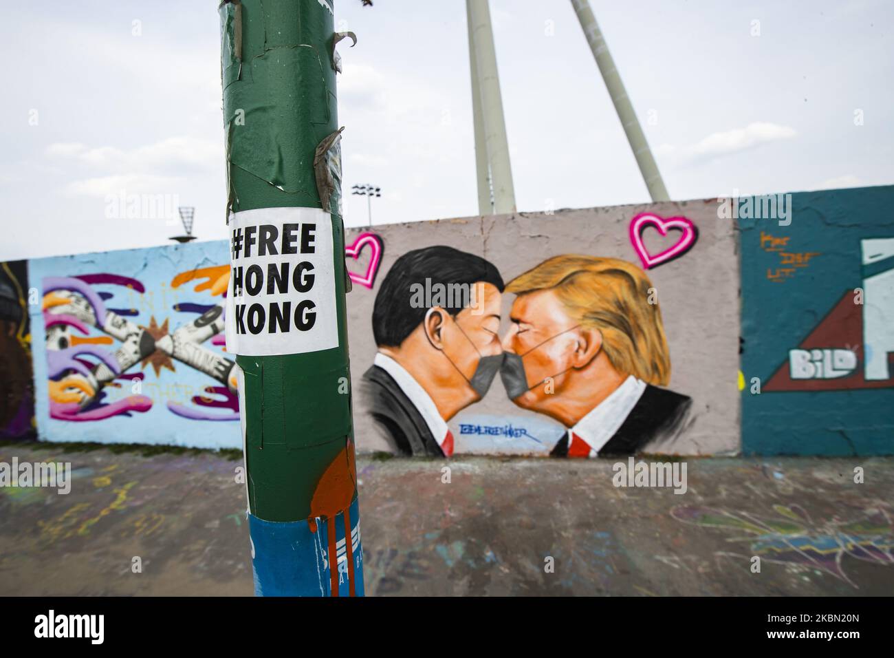 A grafitti of the artist Eme Freethinker representing US President Donald Trump and Chinese President Xi Jinping kissing while wearing a protective mask and a sticker 'Free Hong Kong' are seen in Berlin on April 28, 2020. (Photo by Emmanuele Contini/NurPhoto) Stock Photo