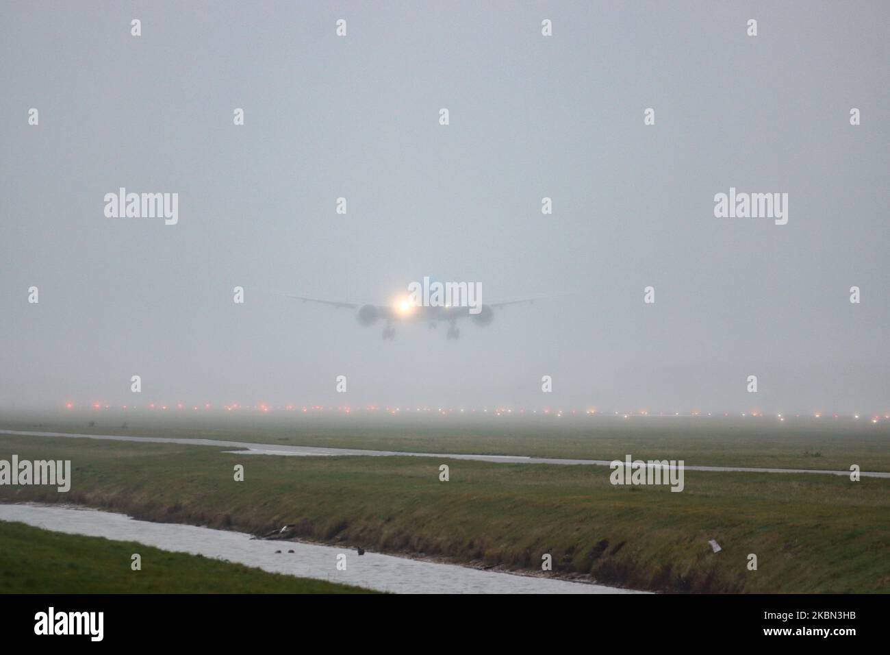 A KLM ASIA Boeing 777-200 commercial aircraft as seen on final approach landing at Polderbaan runway at Amsterdam Schiphol International Airport AMS EHAM in bad weather with mist and rain. The Boeing 777 or B772 wide body long haul airplane has the registration PH-BQK and the name of Mount Kilimanjaro while is powered by 2x GE jet engines. KLM Koninklijke Luchtvaart Maatschappij KL is the flag carrier of the Netherlands, the oldest airline in the world and member of SkyTeam aviation alliance. February 28, 2020 (Photo by Nicolas Economou/NurPhoto) Stock Photo
