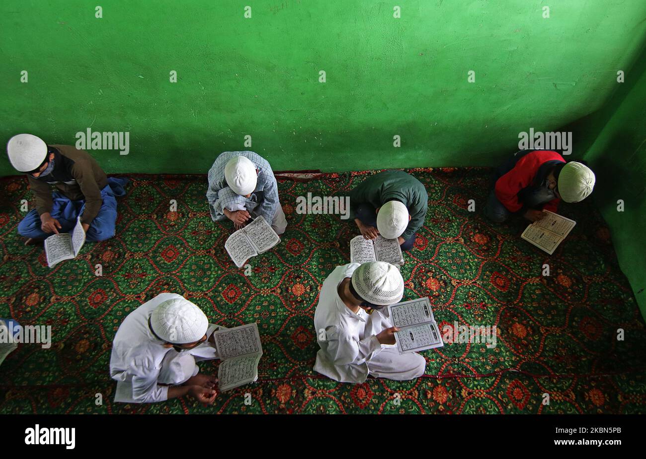Kashmiri boys reciting the holy Quran in an orphanage on the 7th day of Ramadan on the outskirts of Srinagar, Kashmir on May 01, 2020.Strict restrictions continue to remain in place across the Kashmir valley after the Indian Prime Minister Narendra Modi extended the lockdown across the country till May 03 to fight the COVID-19 coronavirus pandemic. Authorities across the Kashmir valley have ordered closure of all religious places as a preventive measures to stop the spread of COVID-19 coronavirus. (Photo by Faisal Khan/NurPhoto) Stock Photo