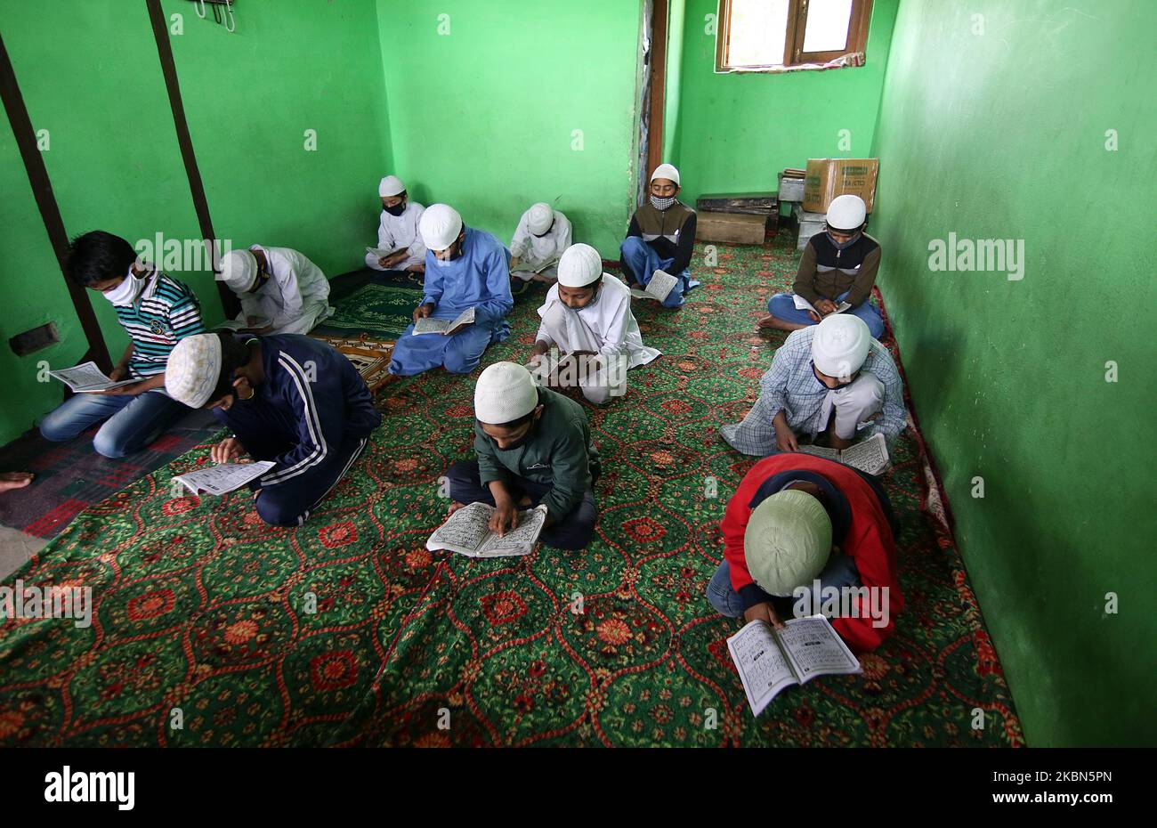 Kashmiri boys are seen reciting the holy Quran in an orphanage on the 7th day of Ramadan on the outskirts of Srinagar, Kashmir on May 01, 2020.Strict restrictions continue to remain in place across the Kashmir valley after the Indian Prime Minister Narendra Modi extended the lockdown across the country till May 03 to fight the COVID-19 coronavirus pandemic. Authorities across the Kashmir valley have ordered closure of all religious places as a preventive measures to stop the spread of COVID-19 coronavirus. (Photo by Faisal Khan/NurPhoto) Stock Photo