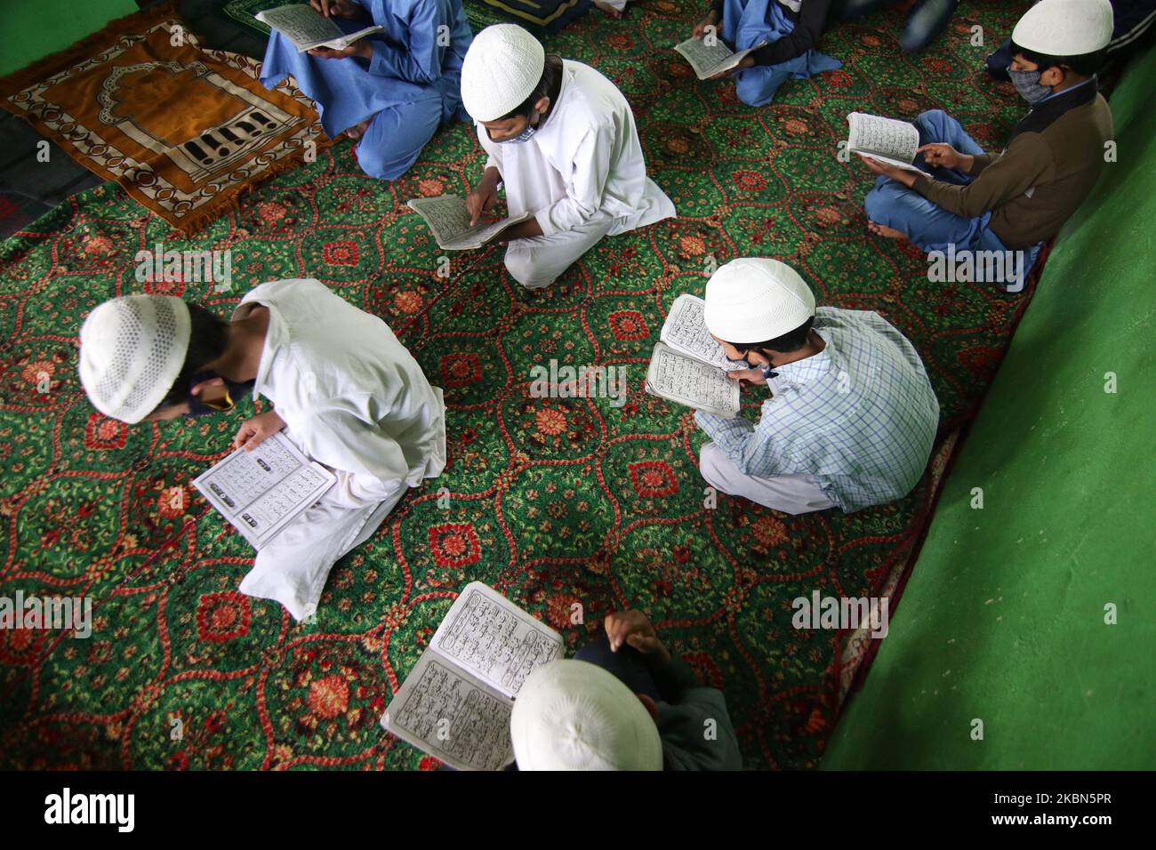 Kashmiri boys are seen reciting the holy Quran in an orphanage on the 7th day of Ramadan on the outskirts of Srinagar, Kashmir on May 01, 2020.Strict restrictions continue to remain in place across the Kashmir valley after the Indian Prime Minister Narendra Modi extended the lockdown across the country till May 03 to fight the COVID-19 coronavirus pandemic. Authorities across the Kashmir valley have ordered closure of all religious places as a preventive measures to stop the spread of COVID-19 coronavirus. (Photo by Faisal Khan/NurPhoto) Stock Photo