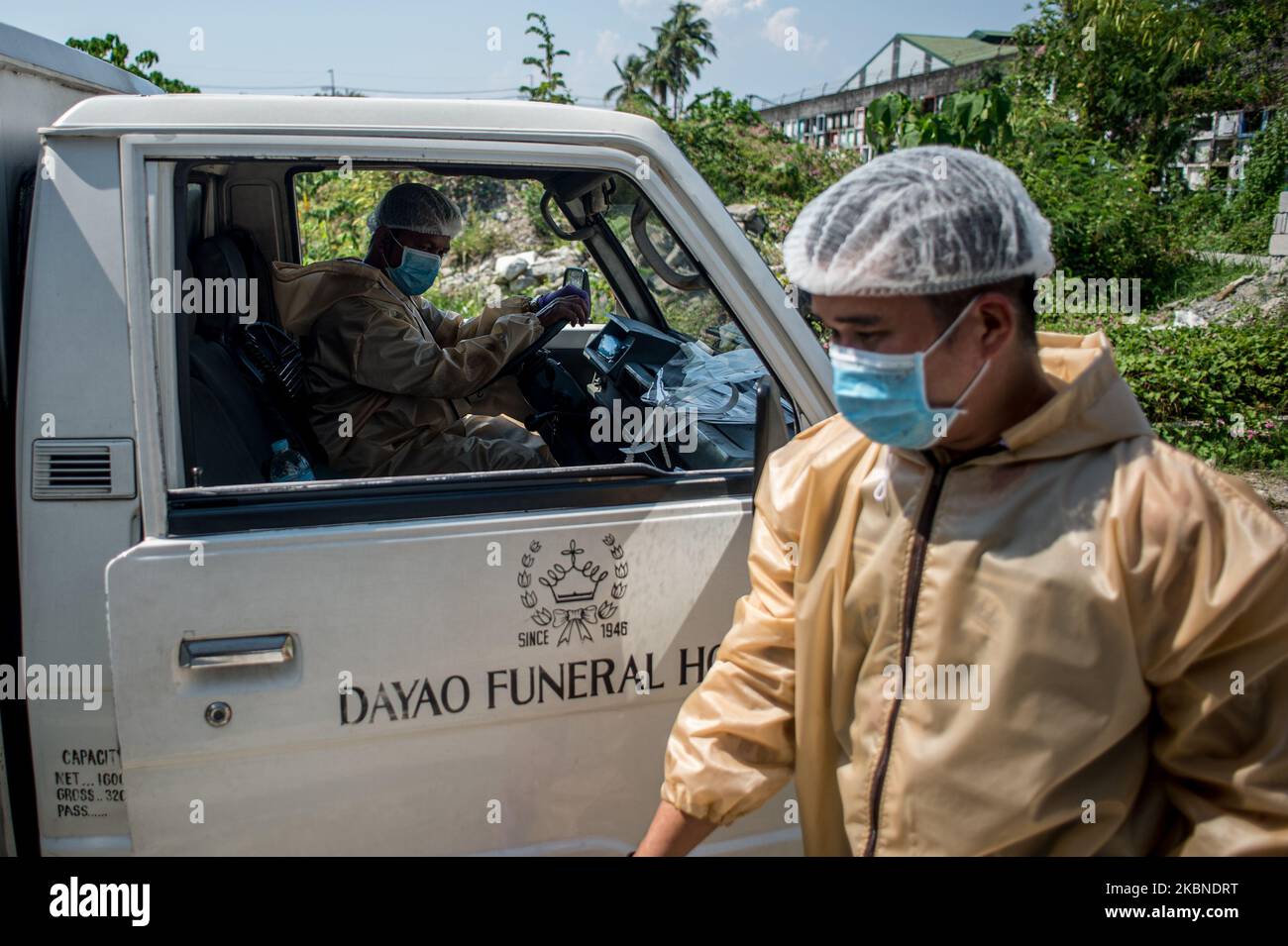 Funeral workers wearing hazmat suits leave the crematorium that handles