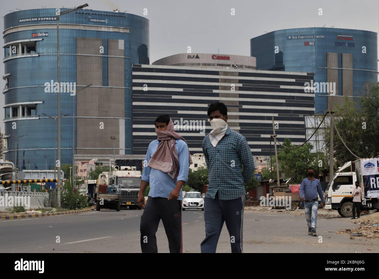 Indian men wearing face masks walk near DLF Building 5 amid COVID-19 coronavirus pandemic in Gurugram on the outskirts of New Delhi, India on 10 May 2020. DLF Cyber City houses some of the top IT and Fortune 500 companies. As one of the largest hives of IT activity in Delhi, it has been referred to as a â€œfuturistic commercial hubâ€. (Photo by Nasir Kachroo/NurPhoto) Stock Photo