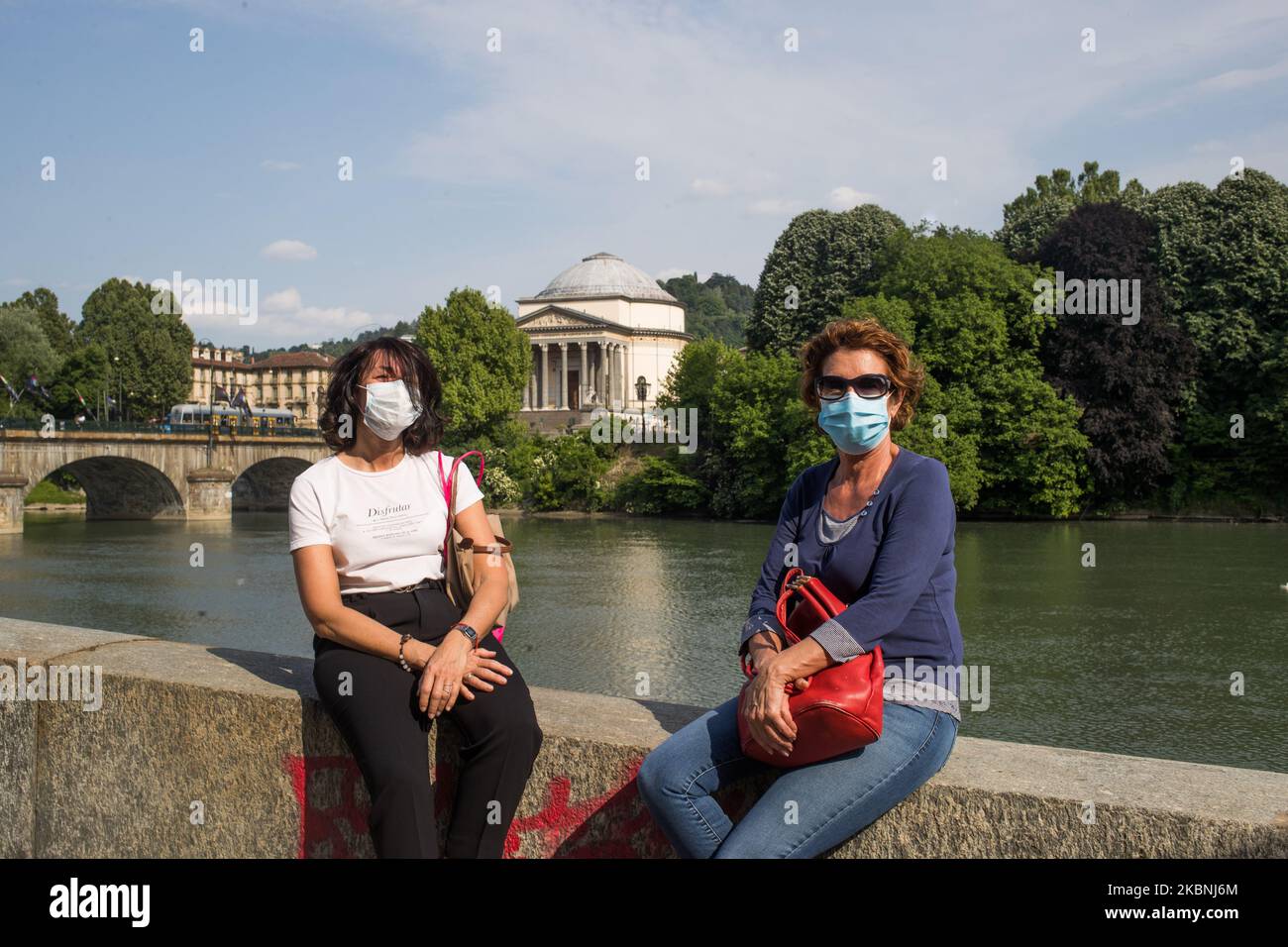 Two women speak on the Po riverside at Parco del Valentino (Valentino Park) during first weekend of phase two (2) of COVID-19 coronavirus emergency, in Turin, Italy, on May 9, 2020. During phase two Italians are allowed to return to work, to see their relatives, to do outdoor sports activities. (Photo by Mauro Ujetto/NurPhoto) Stock Photo