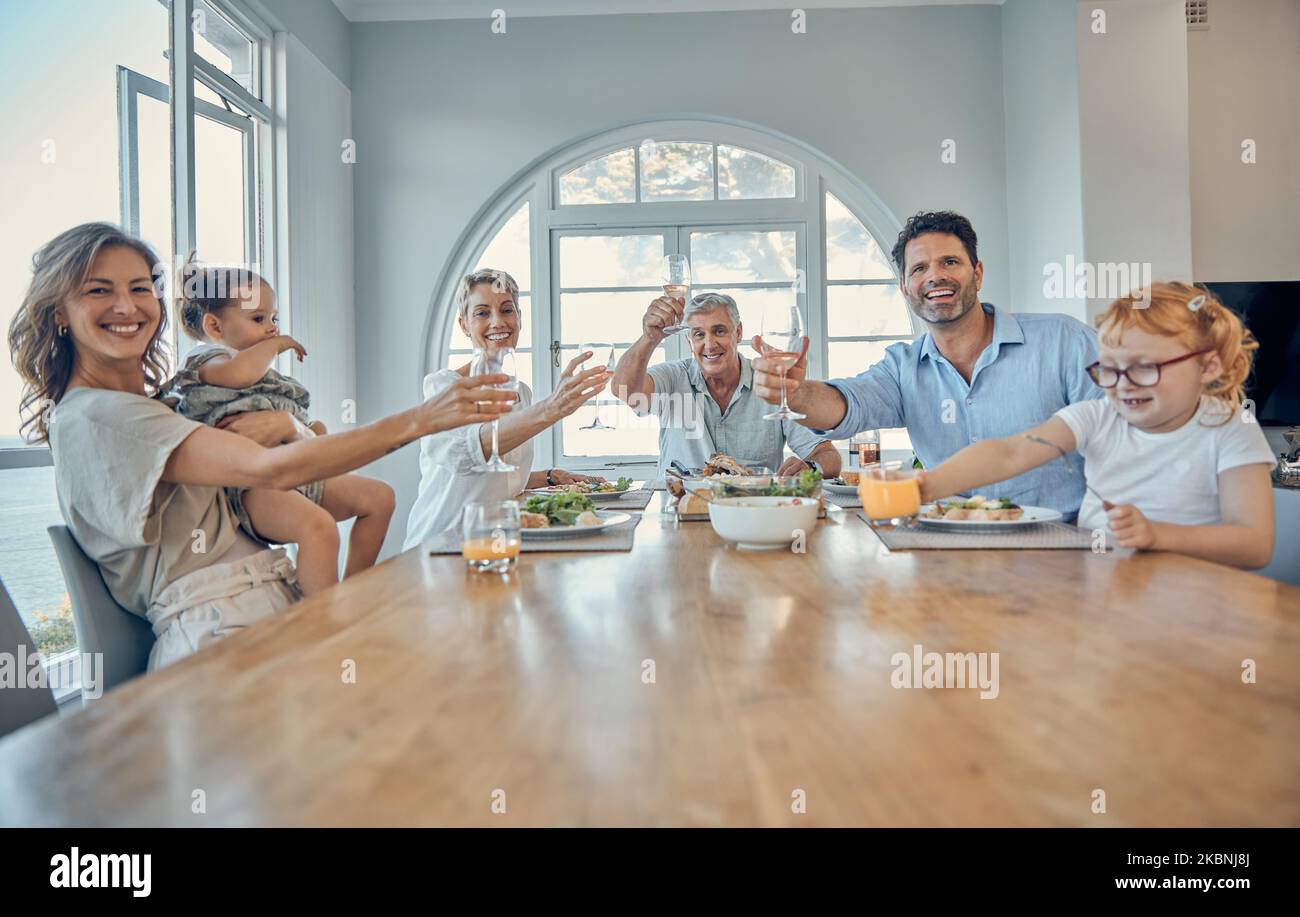 Family, dinner food and cheers of a mother, senior people and children happy at home. Portrait of a happy toast, mother and father with children care Stock Photo