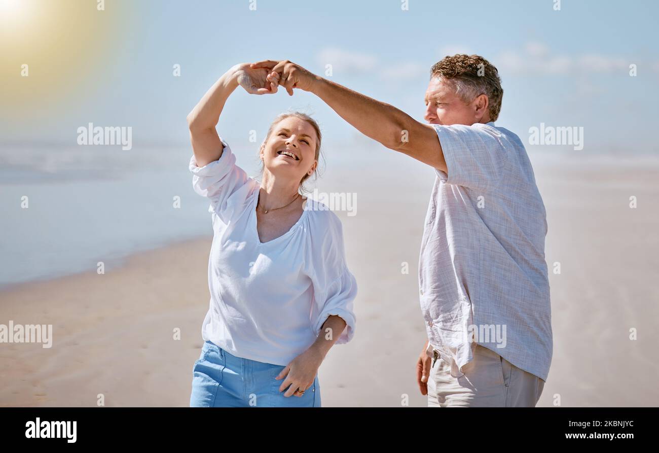 Happy senior couple, dancing and beach for summer vacation, romance or bonding together in the outdoors. Elderly man and woman with smile for romantic Stock Photo