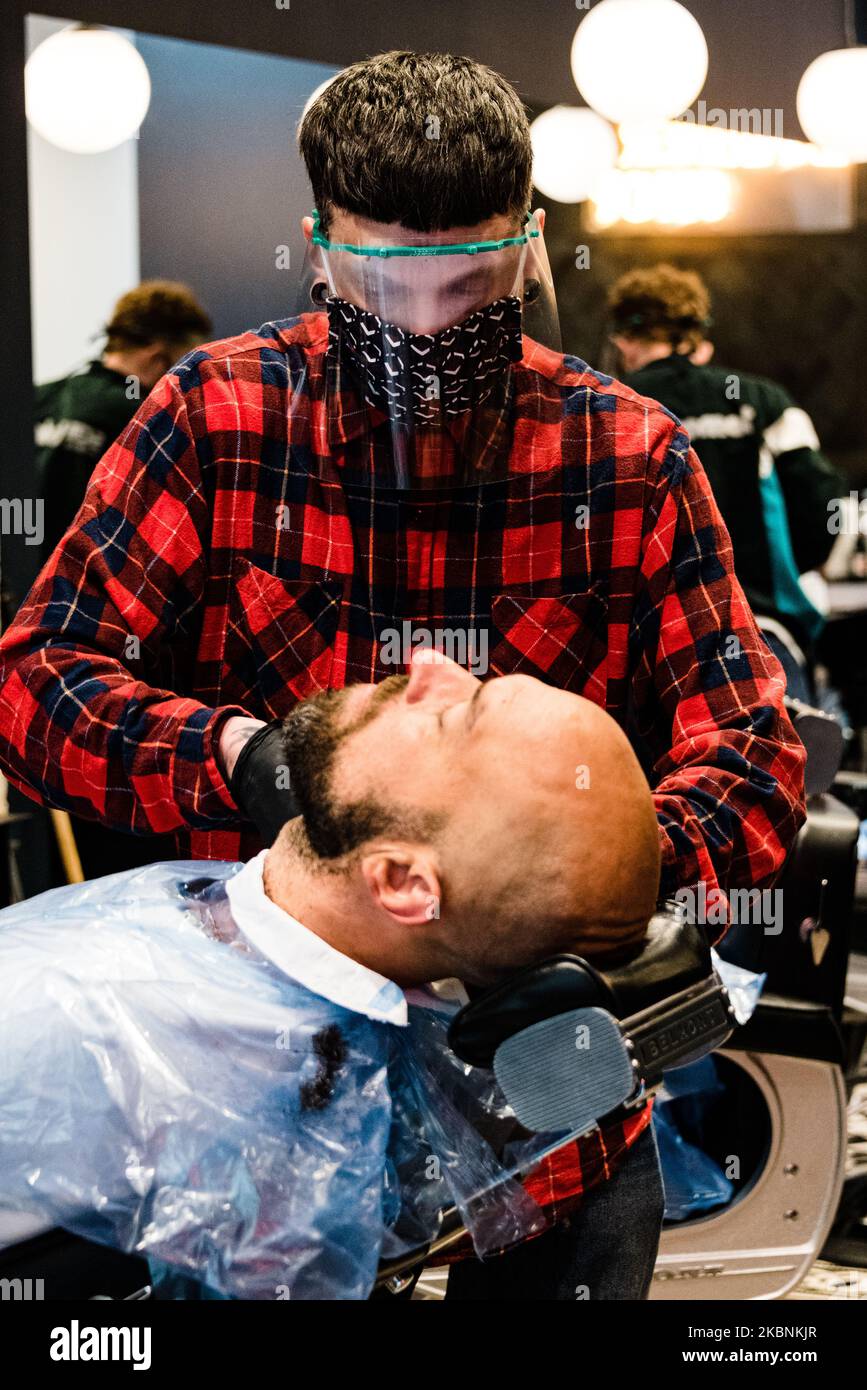 A hairdresser wearing protective mask works at a hair saloon in Paris