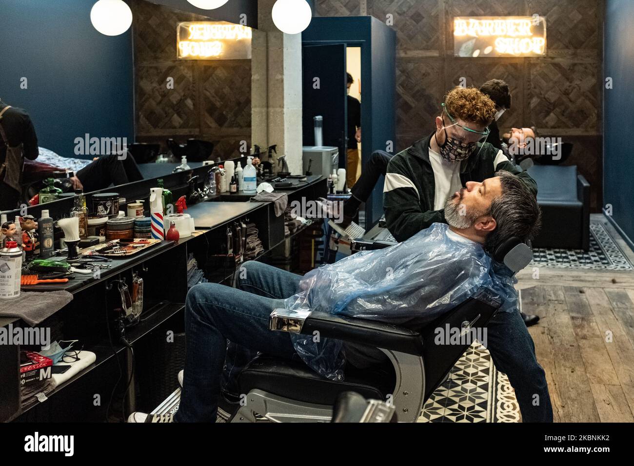 A hairdresser wearing protective mask works at a hair saloon in Paris, France, on May 11, 2020