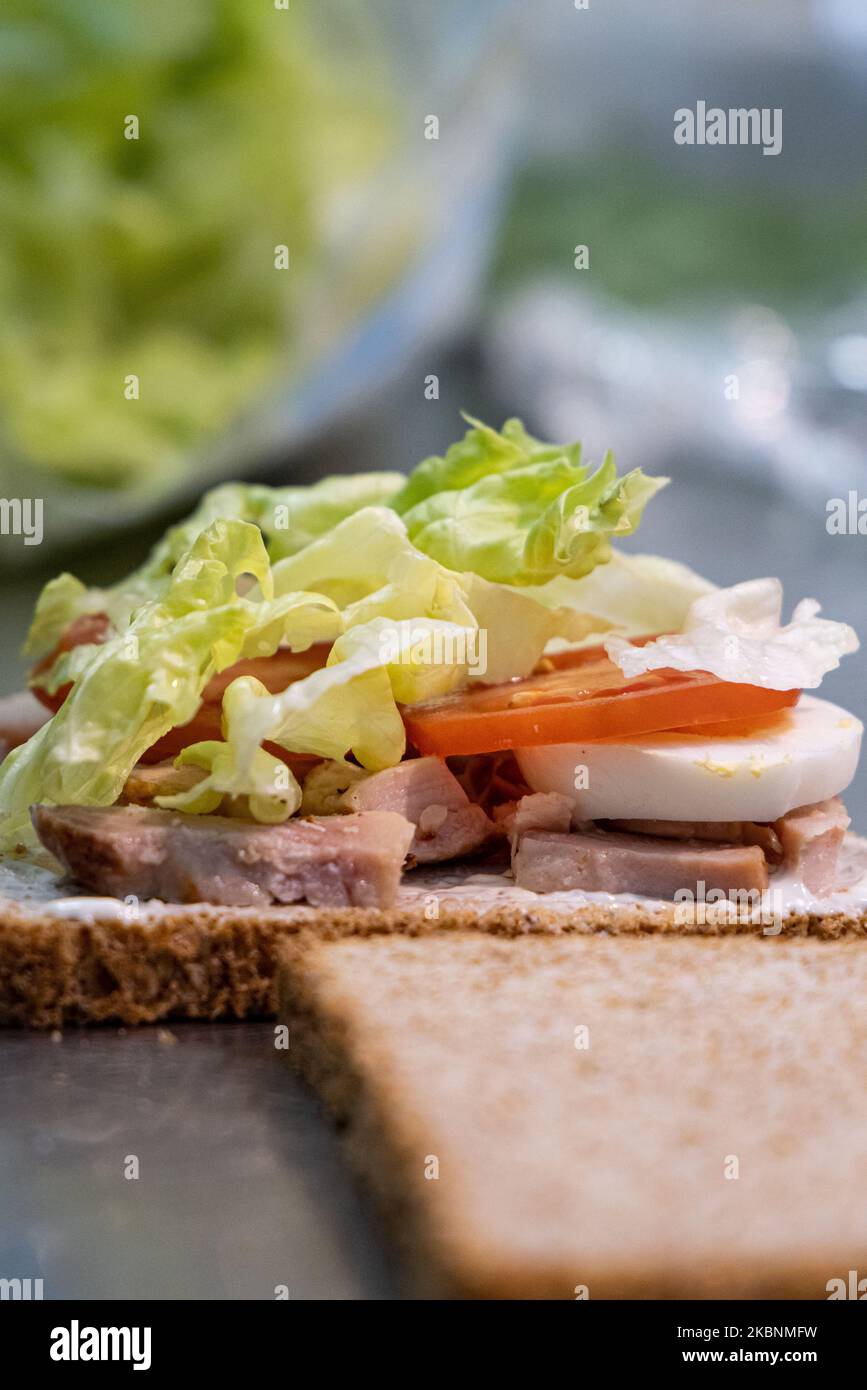 Fresh deli counter in a Cora hypermarket. Employee preparing a sandwich with sliced bread Stock