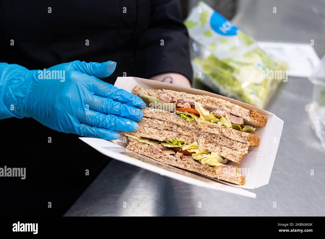 Fresh deli counter in a Cora hypermarket. Employee preparing a sandwich with sliced bread Stock