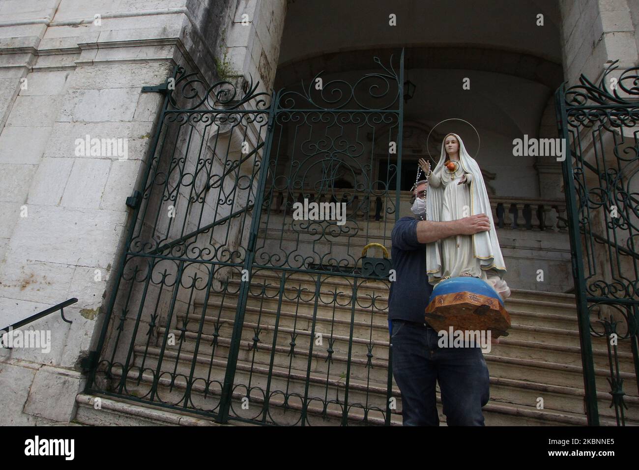 An assistant from the church of Penha de FranÃ§a carries of Virgin Mary image to be prepared for the pilgrimage in the different streets of Lisbon. 12th May 2020. At the suggestion of the Portuguese government to maintain a social distance in order to avoid the spread of COVID-19, many social activities have been cancelled and others modified in their programming, such is the case of the religious festivities in honor of Virgin of Fatima whose central day is May 13 and that the authorities of the Catholic Church have decided to celebrate it as a pilgrimage 'without pilgrims', which consists of Stock Photo