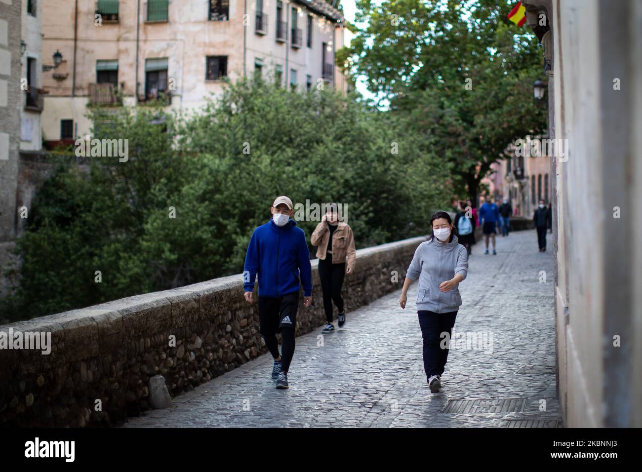 Some people take a walk with face masks on the touristy Carrera del Darro Street on May 12, 2020 in Granada, Spain. Spain is following a plan that consists of four phases, so that people and cities slowly return to normal life. The city of Granada is still in phase 0 until next week due to the decision of the health authorities. (Photo by Fermin Rodriguez/NurPhoto) Stock Photo