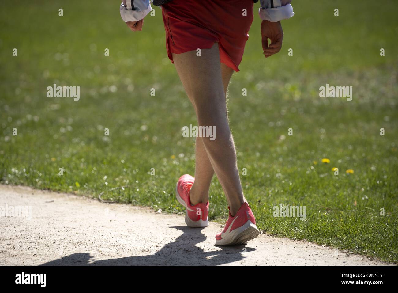 A man wearing shorts and Nike runing shoes is seen in the Royal Baths park in Warsaw, Poland on April 20, 2020. (Photo by Jaap Arriens/NurPhoto) Stock Photo