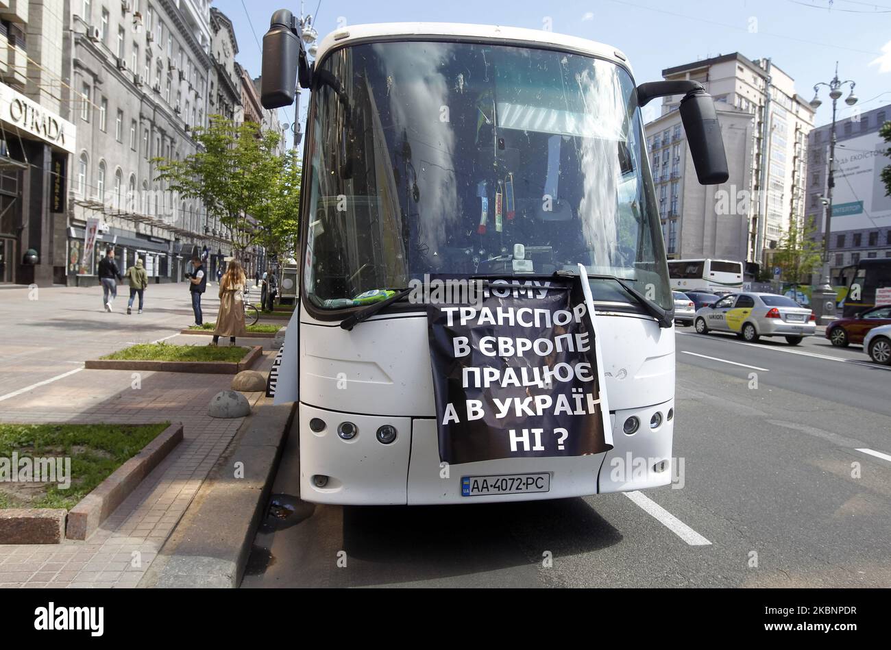 The placard placed on a bus reading like 'Why does transport work in Europe, but not work in Ukraine?' is seen on the Evropeyska Square during a protest demanding to restore domestic and international transportation, in Kyiv, Ukraine, on 13 May, 2020. Bus drivers from all over the country gathered for the protest in the center of the Ukrainian capital. The carriers demand permission from the Cabinet of Ministers for domestic and international transportation, suspended due to the introduction of quarantine due the COVID-19 coronavirus, as local media reported. The placards placed on the buses t Stock Photo