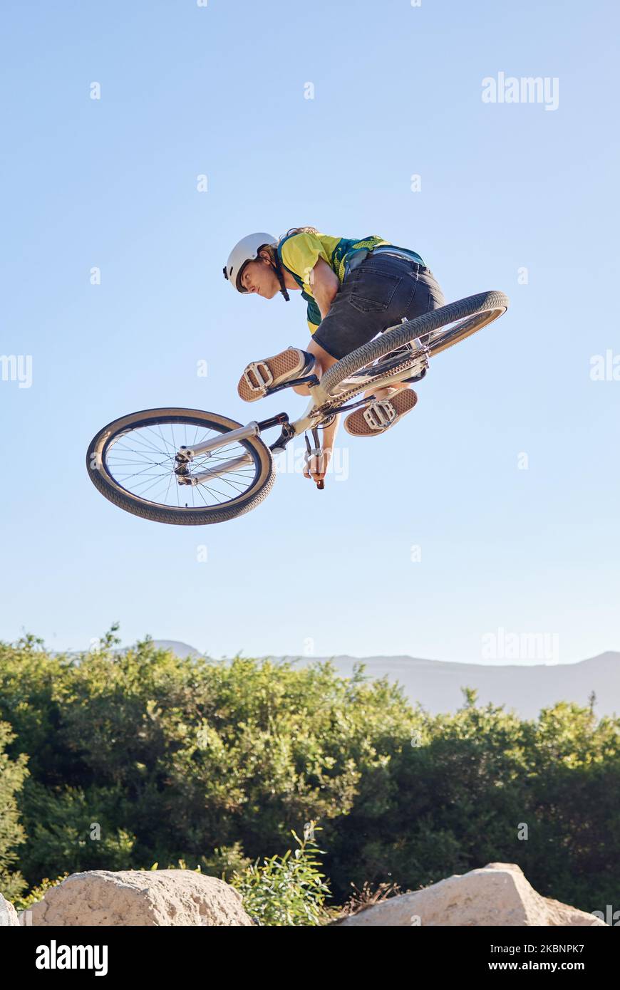 Bike, extreme sport and outdoor fitness, man does dangerous stunt, sports motivation and training in nature. Exercise, athlete with mountain bike Stock Photo