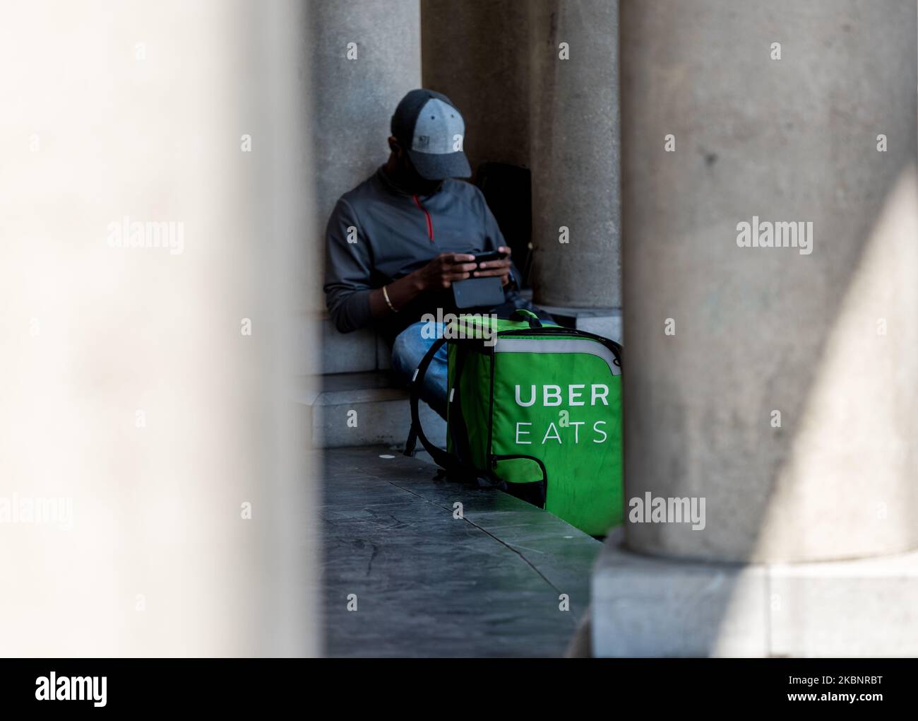 Uber Eats delivery courier is seen taking a break in Ghent, Belgium on May 14, 2020. As Belgium takes steps in easing Restrictions, Restaurant and cafe are not allowed to open to customers only fast food and take away is allowed. restaurants and restaurants may not reopen before June 8. (Photo by Jonathan Raa/NurPhoto) Stock Photo