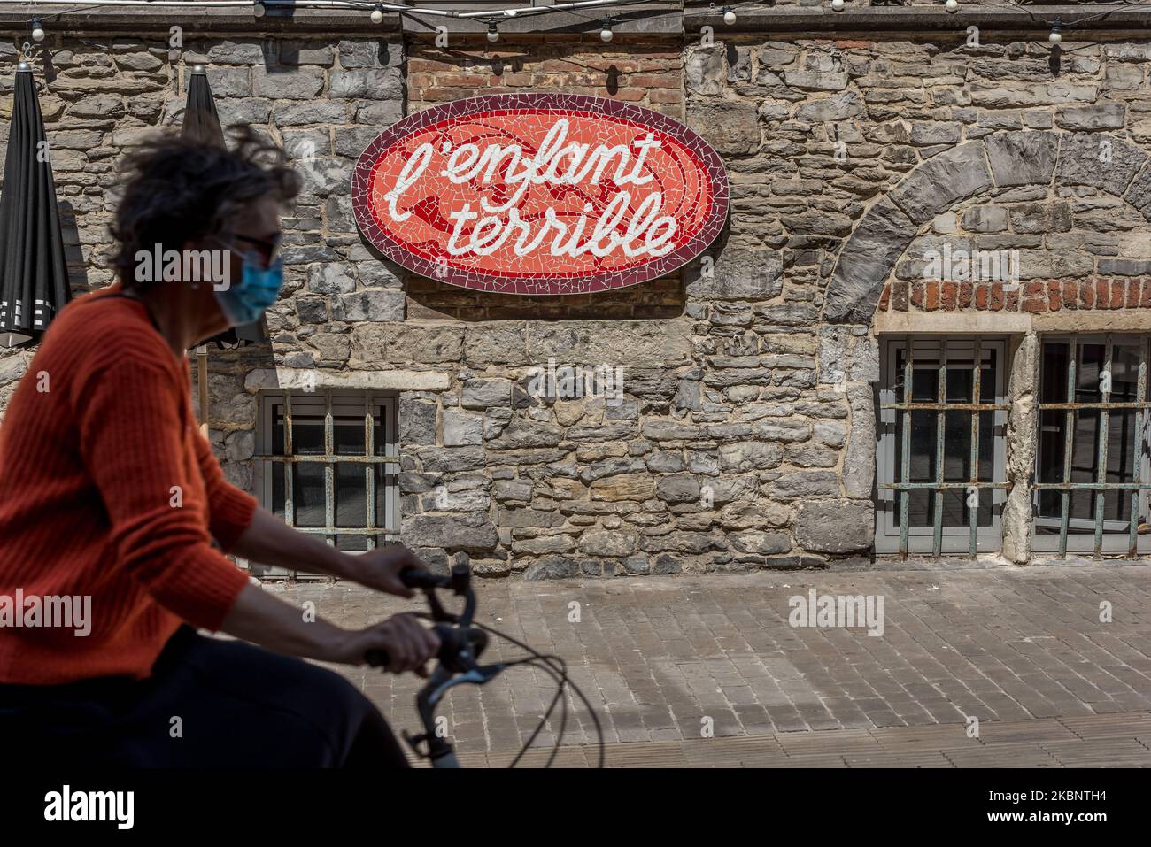 A Woman is seen on her bicycle with face mask as a precaution against transmission of the coronavirus in Ghent - Belgium 15 May 2020. Belgium compulsory face mask on public transport and strongly recommended in other places. Belgium start with the opening of shops allowing more people to work again, on condition. Belgium start cautiously with a way out of the corona measures. (Photo by Jonathan Raa/NurPhoto) Stock Photo