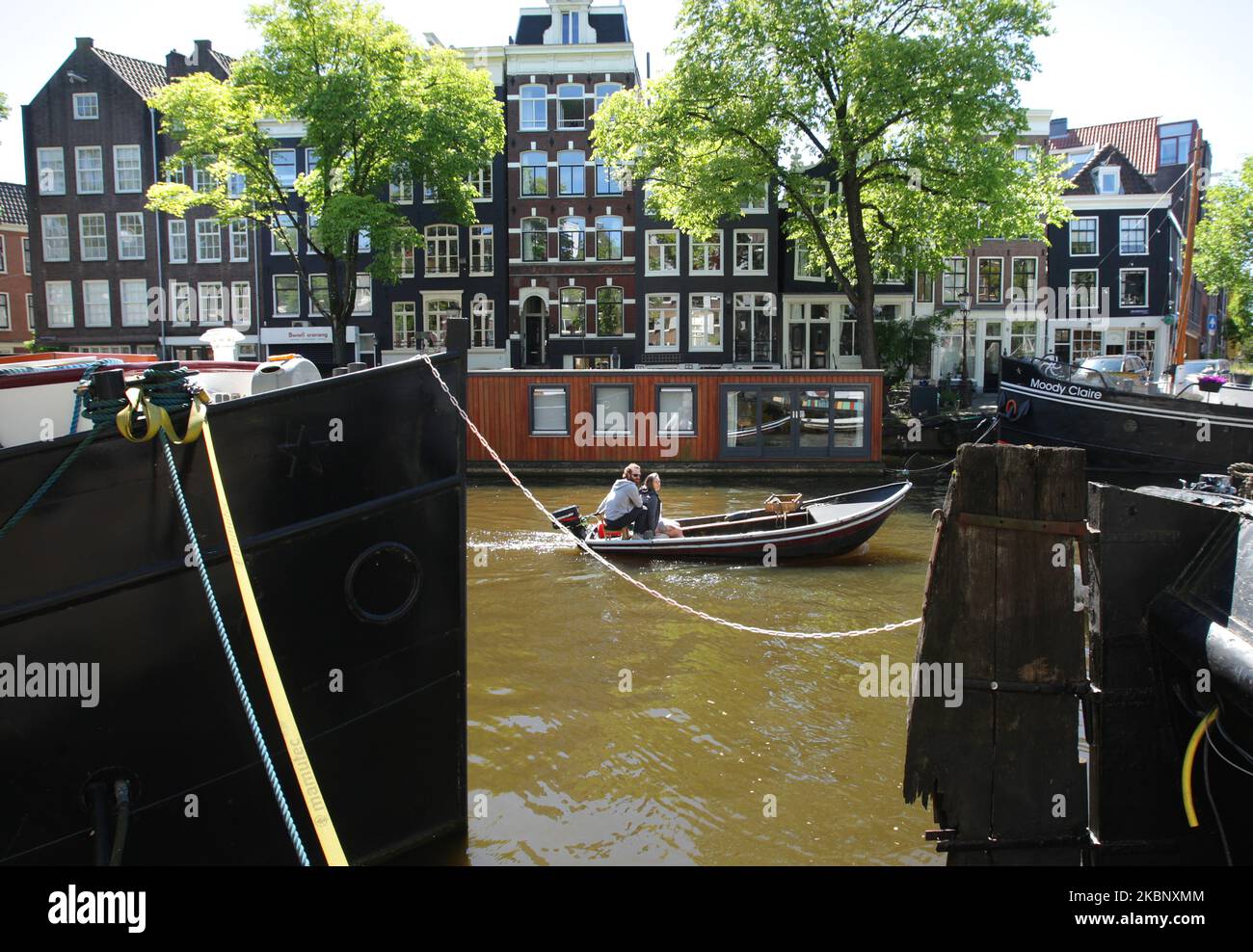 A couple enjoying on the boat at the Brouwersgracht canal during sunny day amid the Coronavirus pandemic on May 17, 2020 in Amsterdam,Netherlands. Amsterdam city hall reopen the canals today after sailing ban has been imposed for every weekend, due to the slow flexibilisation of the corona measure. (Photo by Paulo Amorim/NurPhoto) Stock Photo