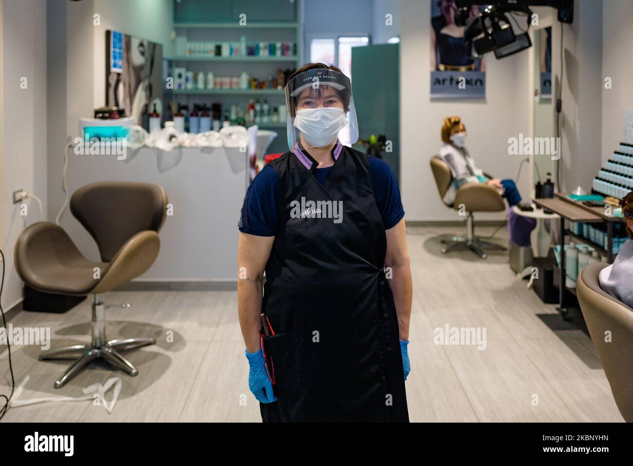 A hairdresser poses while at work in her salon on May 18 in Molfetta