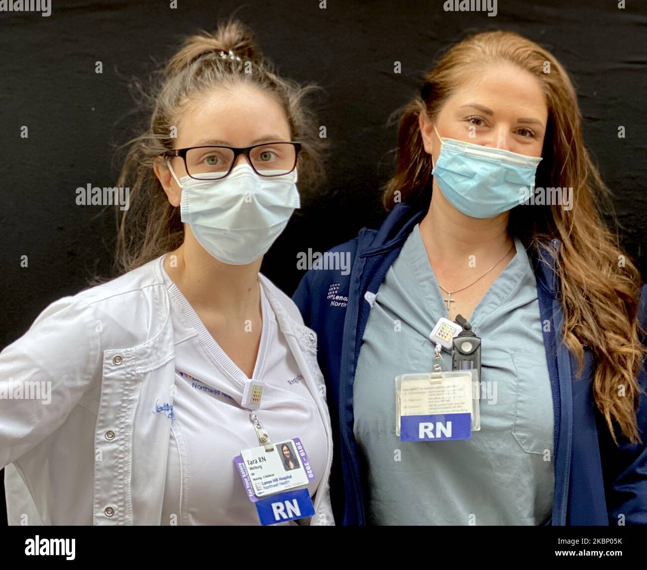 Nurses at Lenox Hill Hospital pose outside at the hospital as people