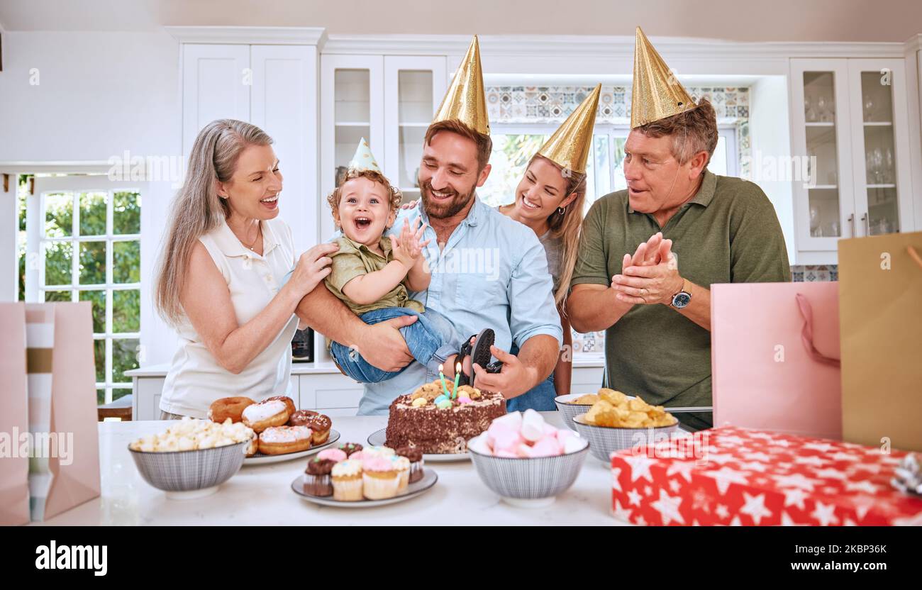 Baby, birthday party and family celebration at a kid event with mother, father and friends. Young child and parents celebrate event with food clapping Stock Photo