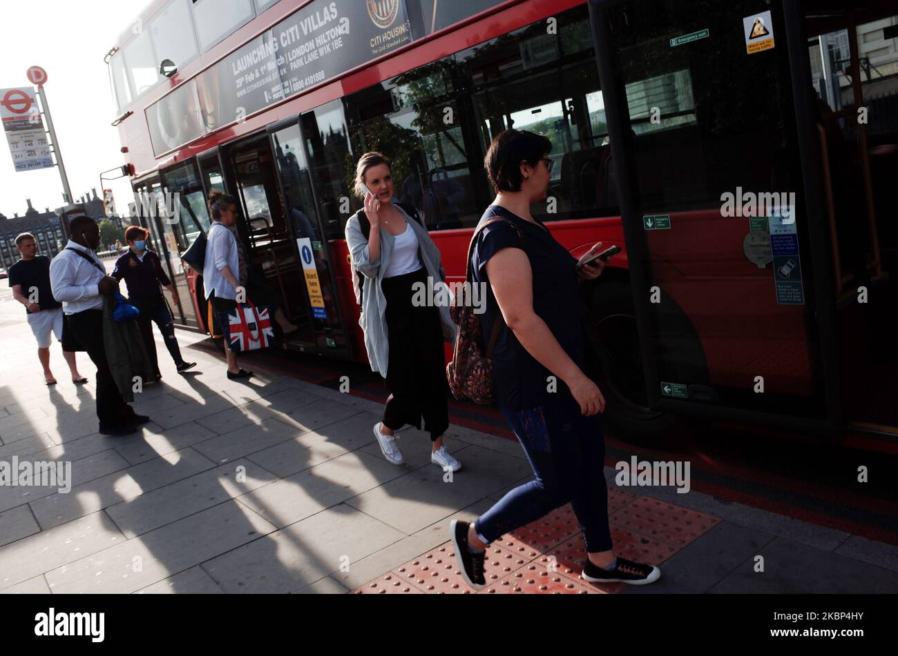 People board a bus on Westminster Bridge Road in London, England, on May 21, 2020. Coronavirus cases are believed to be dropping to very low levels across the capital, with none at all recorded this Monday, according to data from Public Health England, and media reporting yesterday that six major London hospitals had recorded no covid-19 deaths for the previous 48 hours. UK-wide deaths meanwhile stand at 36,042 according to the daily total released this afternoon by the Department of Health and Social Care. (Photo by David Cliff/NurPhoto) Stock Photo