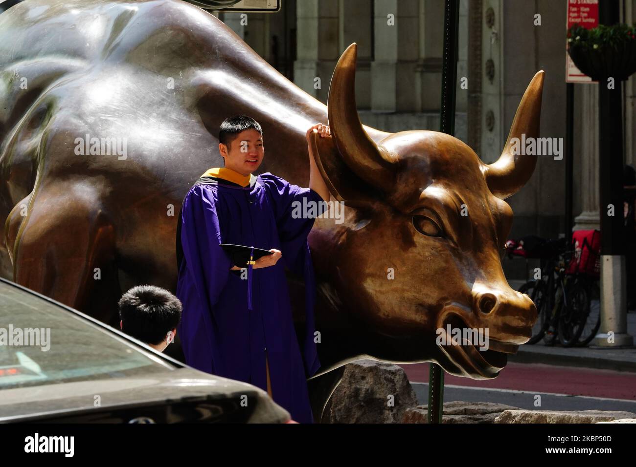 A view of new graduates taking photos at the Charging Bull during the coronavirus pandemic on May 20, 2020 in Bowling Green, New York City. COVID-19 has spread to most countries around the world, claiming over 316,000 lives with over 4.8 million infections reported. (Photo by John Nacion/NurPhoto) Stock Photo