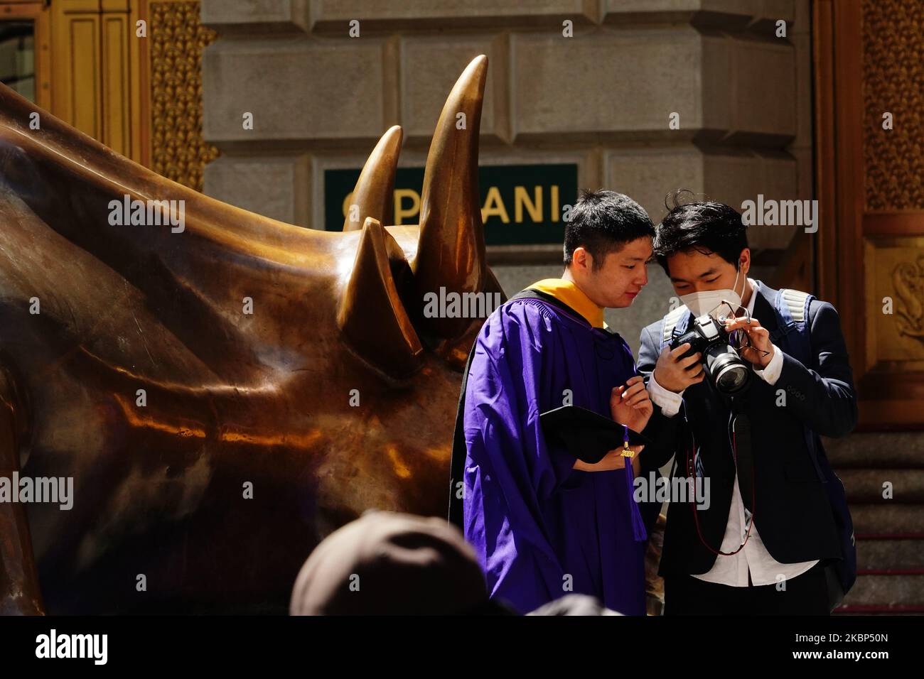 A view of new graduates taking photos at the Charging Bull during the coronavirus pandemic on May 20, 2020 in Bowling Green, New York City. COVID-19 has spread to most countries around the world, claiming over 316,000 lives with over 4.8 million infections reported. (Photo by John Nacion/NurPhoto) Stock Photo