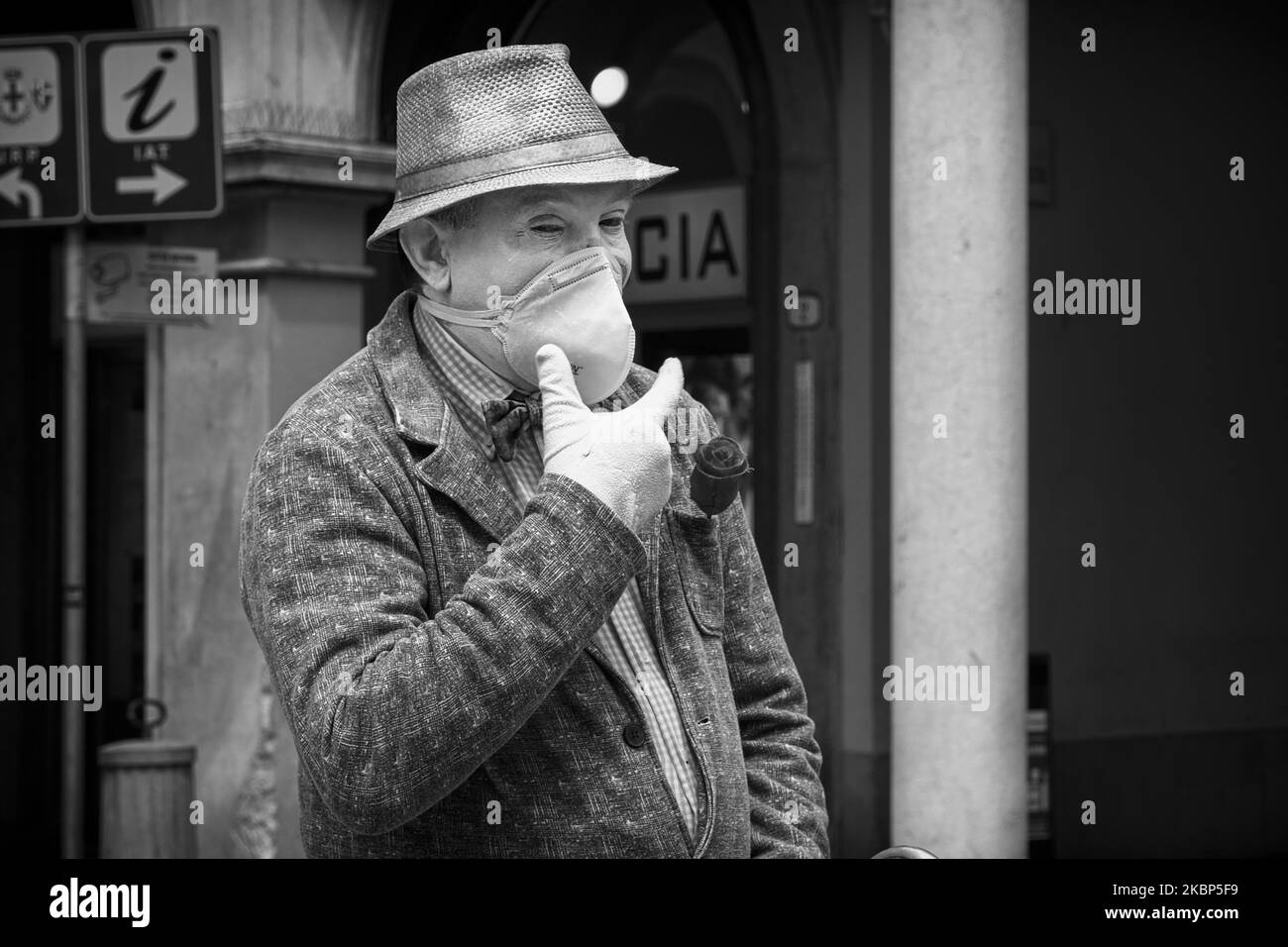 (EDITOR'S NOTE: Image was converted to black an white) The new decree gave the green light to the reopening of the open-air markets and bars. Obligation to wear masks, gloves and to maintain a safety distance of one meter or more. The historic Pedrocchi cafe in Padua has reopened its doors by changing the method of table service and drastically reducing the number of seats inside.In the photo, a mime with a mask performs in the square near the Caffe Pedrocchi. On 22th May, 2020 in Padua, Italy. (Photo by Roberto Silvino/NurPhoto) Stock Photo