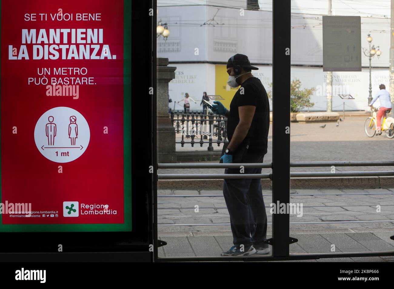 A passenger is waiting for the tram wearing the protective mask in Milan on May 22, 2020 in Milan, Italy. Restaurants, bars, cafes, hairdressers and other shops have reopened, subject to social distancing measures, after more than two months of a nationwide lockdown meant to curb the spread of Covid-19 (Photo by Mairo Cinquetti/NurPhoto) Stock Photo