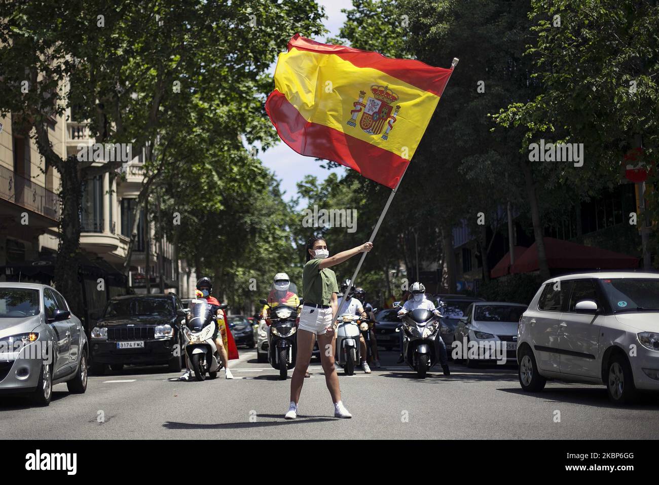 A protester waves a flag of Spain at the demonstration against the spanish government for its management of the coronavirus pandemic, and demanding the definitive end of the lockdown, in Barcelona, on may 23, 2020. (Photo by Robert Bonet/NurPhoto) Stock Photo