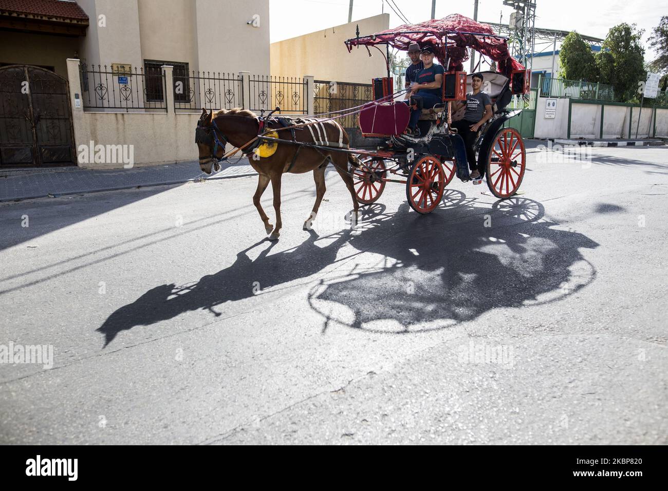 Palestinians use a horse cart at the street during the Eid al-Fitr marking the end of the holy fasting month of Ramadan in Gaza City, on 24 May, 2020. amid concerns about the spread of the coronavirus disease (COVID-19) in the Gaza Strip. The Palestinian Ministry of Health in Gaza confirmed that thirty-five new cases of the coronavirus and a woman is death that causes in the Gaza Strip from 19 to 21 May 2020. (Photo by Sameh Rahmi/NurPhoto) Stock Photo