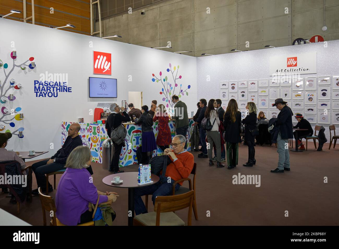 TURIN, ITALY - NOVEMBER 04, 2022: Illy coffee stand with people and Pascale Marthine Tayou artwork at Artissima 2022, contemporary art fair vernissage Stock Photo