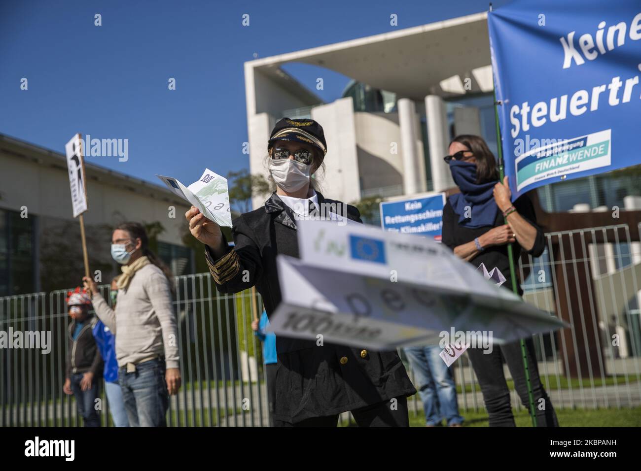An activist dressed as an airline stewardess holds up oversized fake versions of Euro currency at a protest outside the Chancellery against the recent Lufthansa bailout during the coronavirus crisis on May 27, 2020 in Berlin, Germany. (Photo by Emmanuele Contini/NurPhoto) Stock Photo