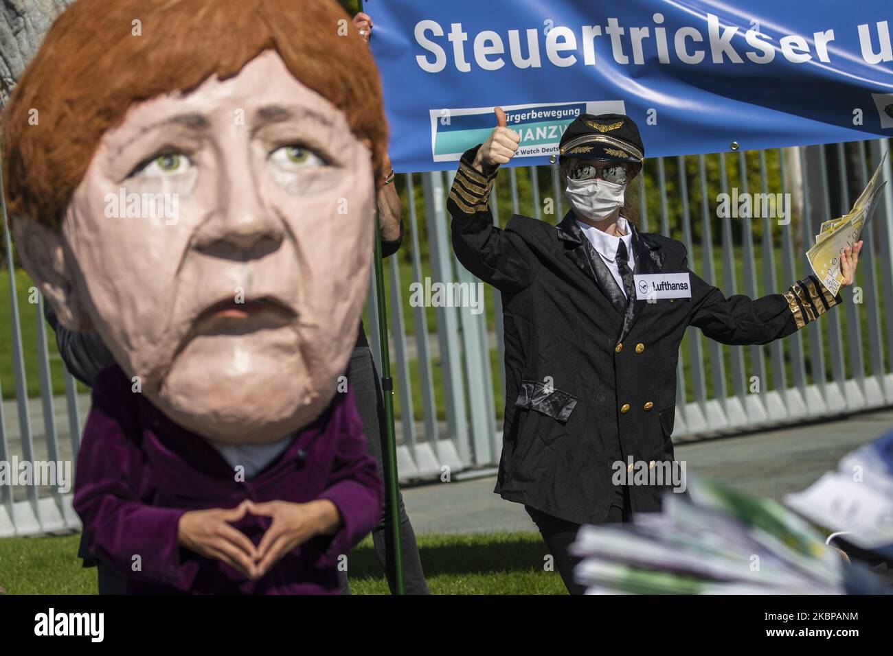 An activist dressed as an airline stewardess and an activists dressed as German Chancellor Angela Merkel taking part in a protest outside the Chancellery against the recent Lufthansa bailout on May 27, 2020 in Berlin, Germany. (Photo by Emmanuele Contini/NurPhoto) Stock Photo