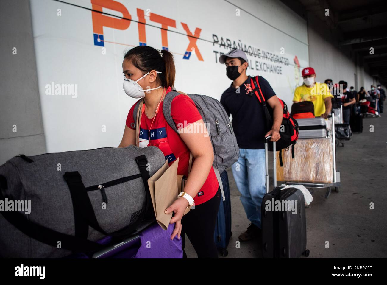 Returning overseas Filipino workers (OFW) queue outside a terminal as