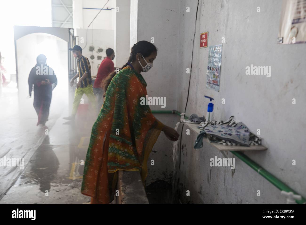 Garment workers washing hands before entering an apparel factory in