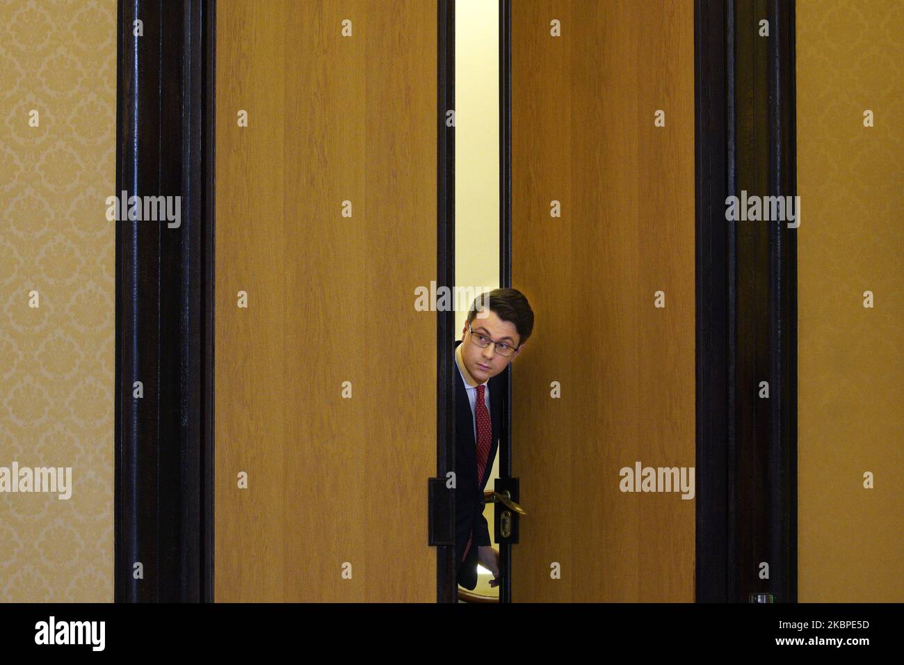 A man looks through an open door ahead of a press conference at the Chancellery of the Prime Minister (KPRM) on May 27, 2020 in Warsaw, Poland. (Photo by Jaap Arriens/NurPhoto) Stock Photo
