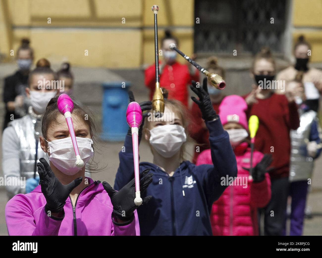 Gymnasts of the Deriugina School wearing protective masks amid the Covid-19 coronavirus epidemic take part at a trainning session on a street in central Kyiv, Ukraine, on 01 June, 2020. Young gymnasts had a training on a street to support the 'Save Deriugina School' action, which was organized in support of Irina Deryugina children's and youth sports school of gymnastics. (Photo by STR/NurPhoto) Stock Photo